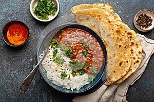Traditional Indian Punjabi dish Dal makhani with lentils and beans in black bowl served with basmati rice, naan flat