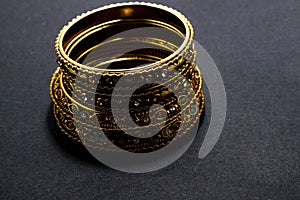 Traditional indian Rajasthani Diamond gold bangles ring jewellery vintage artifact on black background.