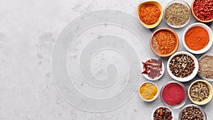 Traditional Indian spices in bowls on grey background