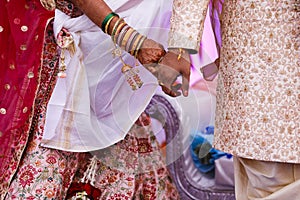 Traditional indian wedding ceremony, groom holding bride hand