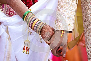 Traditional indian wedding ceremony, groom holding bride hand