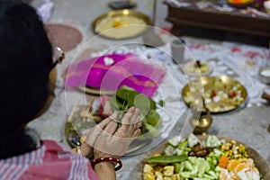 Traditional Indian woman worshipping god with folded hands during pushpanjali ritual of Durga Puja, Saraswati Puja and other