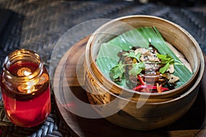 Traditional indonesian food served in a wooden bowl with paprika and chili sauce decorated with corriender during dinner