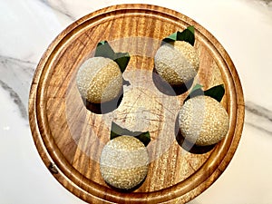 Traditional Indonesian snack called Onde-onde served on a wooden plate on a table photo