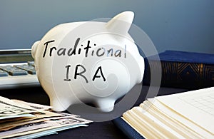 Traditional ira handwritten on a side of piggy bank.