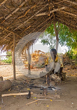 African Giriama ironsmith at work in his hut
