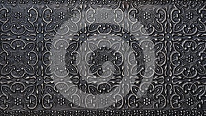 Traditional islamic rhythmic arabesque pattern in form of embossing on metal. Textured black silver carved metal backdrop