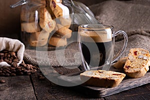 Traditional Italian almond biscuits biscotti served on a wooden board with a cup of aromatic coffee