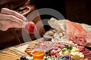 Traditional italian antipasto. Assorted cheeses, grapes, olives, prosciutto, rosemary. Delicious appetiser Italian prosciutto and