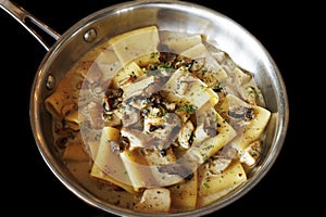 traditional italian creamy wild mushroom pasta with truffle, ceps and porchini, black background