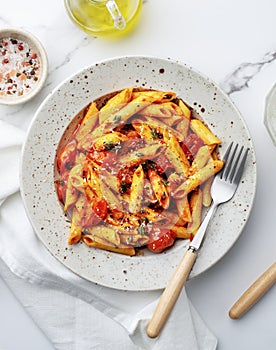 Traditional Italian cuisine, Penne pasta with cherry tomatoes and thyme. Top view, close-up