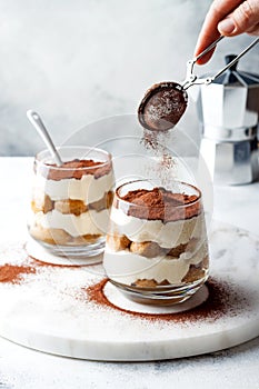 Traditional Italian dessert tiramisu in a glass.