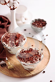 Traditional Italian dessert tiramisu in glasses on white table. Soft focus