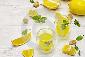 Traditional Italian digestif: liqueur Limoncello with lemons and fragrant mint leaves