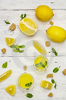 Traditional Italian digestif: liqueur Limoncello with lemons and fragrant mint leaves