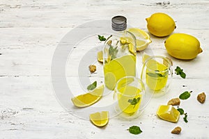 Traditional Italian digestif: liqueur Limoncello with lemons and fragrant mint leaves