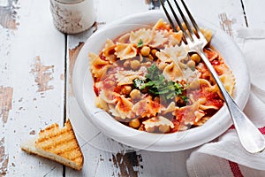 Traditional Italian dish, chowder, pottage, pasta e ceci served in old plate on old wooden background.