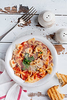 Traditional Italian dish, chowder, pottage, pasta e ceci served in old plate on old wooden background.