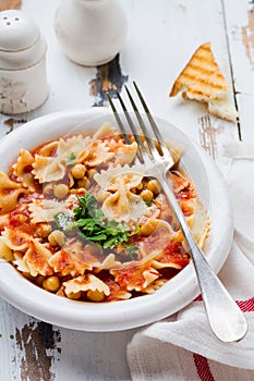 Traditional Italian dish, chowder, pottage, pasta e ceci served in old plate on old wooden background.