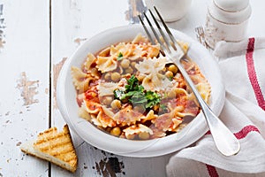 Traditional Italian dish, chowder, pottage, pasta e ceci served in old plate on old wooden background.