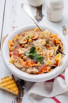 Traditional Italian dish, chowder, pottage, pasta e ceci served in old plate on old wooden background.