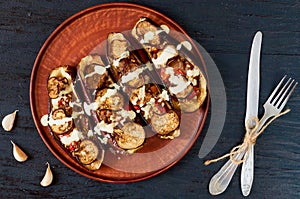 Traditional Italian dish - grilled eggplants stuffed with rise, tomatoes, garlic and sauce on a vintage plate