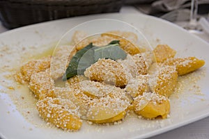 A traditional Italian dish: Pumpkin Gnocchi with Parmesan cheese and a decorative sage leaf