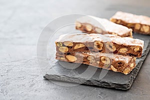 Traditional italian festive chocolate torrone or nougat with nuts close up. Copy space.