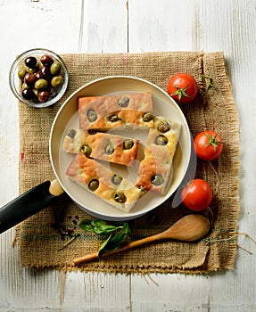 Traditional Italian focaccia with olives on the table