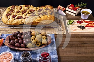 Traditional Italian Focaccia with pepperoni, cherry tomatoes, black olives, rosemary ando onion - homemade flat bread focaccia photo