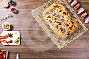 Traditional Italian Focaccia with pepperoni, cherry tomatoes, black olives, rosemary ando onion - homemade flat bread focaccia photo