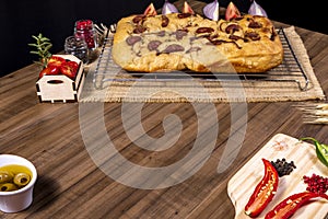 Traditional Italian Focaccia with pepperoni, cherry tomatoes, black olives, rosemary ando onion - homemade flat bread focaccia photo