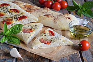 Traditional Italian Focaccia with tomatoes, basil, garlic and sumach. Homemade pastry. Flat bread. Organic flatbread. Rustic style