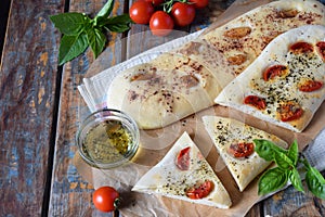 Traditional Italian Focaccia with tomatoes, basil, garlic and sumach. Homemade pastry. Flat bread. Organic flatbread. Rustic style