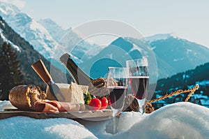 Traditional Italian food and drink outdoor in sunny winter day. Romantic alpine picnic in Dolomites with mountains background