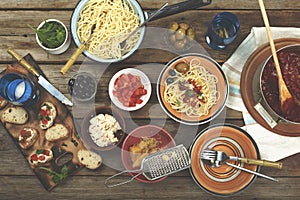 Traditional Italian food. Pasta spaghetti with tomato sauce, olives and garnish with wine on the wooden table