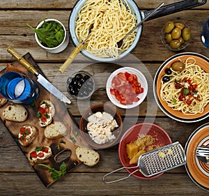 Traditional Italian food. Pasta spaghetti with tomato sauce, olives and garnish with wine on the wooden table