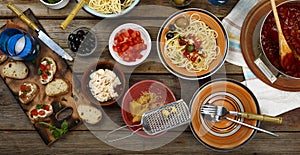 Traditional Italian food. Pasta spaghetti with tomato sauce, olives and garnish with wine on the wooden table
