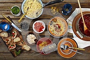 Traditional Italian food. Pasta spaghetti with tomato sauce, olives and garnish with wine on the wooden table. National Spaghetti