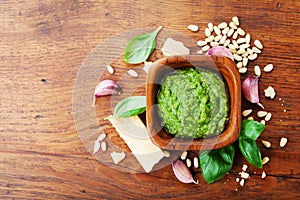 Traditional italian fresh pesto sauce with raw ingredients top view. Healthy and organic food.