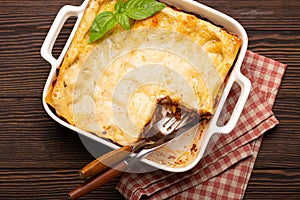 Traditional Italian lasagna on plate on wooden table