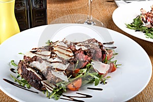 Traditional Italian main dish. Beef tagliata: tender beef rib eye, arugula, cherry tomatoes
