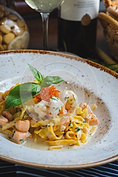 Traditional Italian pasta Carbonara with salmon and red caviar on a plate