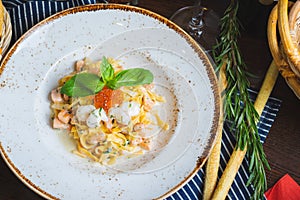 Traditional Italian pasta Carbonara with salmon and red caviar on a plate