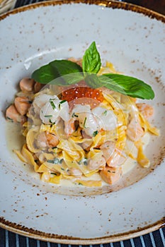 Traditional Italian pasta Carbonara with salmon and red caviar on a plate