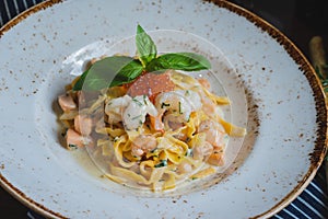 Traditional Italian pasta Carbonara with salmon and red caviar on a plate