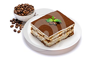 Traditional Italian Tiramisu square dessert portion on ceramic plate and coffee beans isolated on white background with