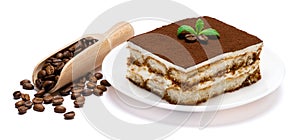 Traditional Italian Tiramisu square dessert portion on ceramic plate and coffee beans isolated on white background with