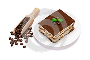 Traditional Italian Tiramisu square dessert portion on ceramic plate and coffee beans isolated on white background with