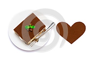 Traditional Italian Tiramisu square dessert portion on ceramic plate and heart shape made of cocoa powder isolated on